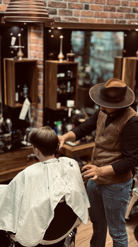 a man in a hat getting a haircut of a man