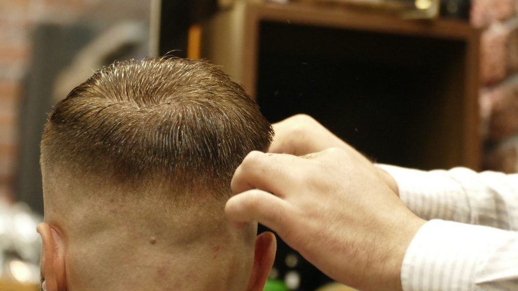 a person cutting hair of a man